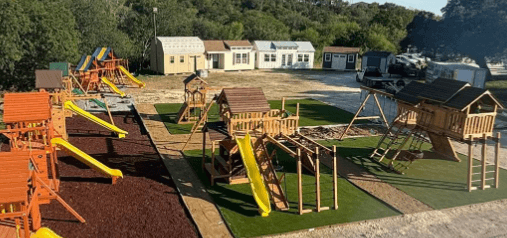 Johnny's Backyard outdoor showroom display lot with playsets and backyard structures